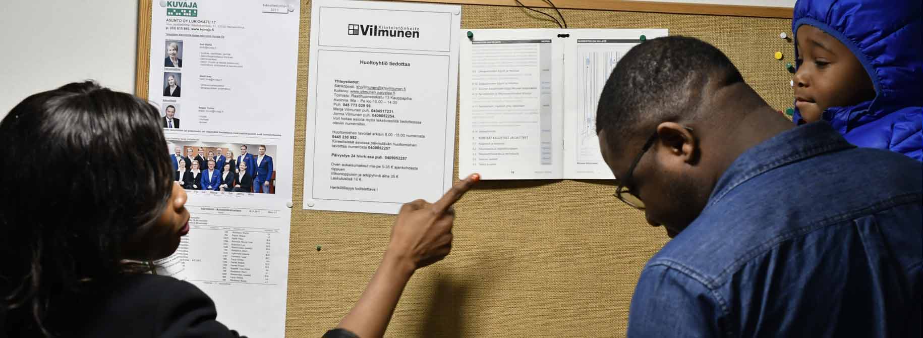 family reads housing company rules on notice board