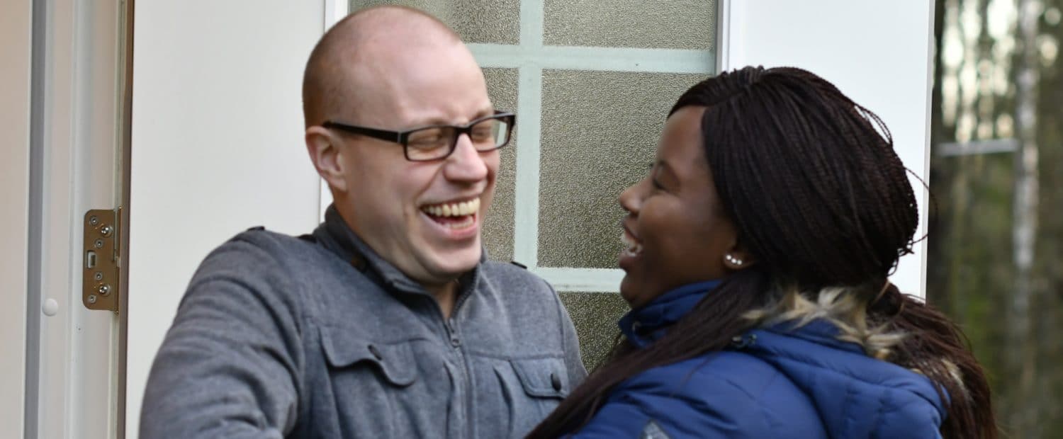 man and woman at the door of their home